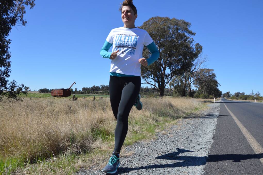 Kirrily Dear stretches her legs on a stretch of local road 
on her way to Broken Hill to start her 1300km run.