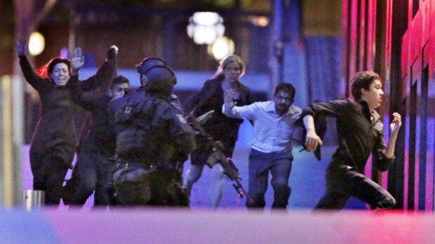 Hostages flee from the Lindt cafe in Martin Place during the early hours of December 16, 2014. Photo: Andrew Meares

