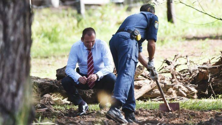 Police officers search the grounds of the semi-rural property in Bonny Hills. Photo: Nick Moir