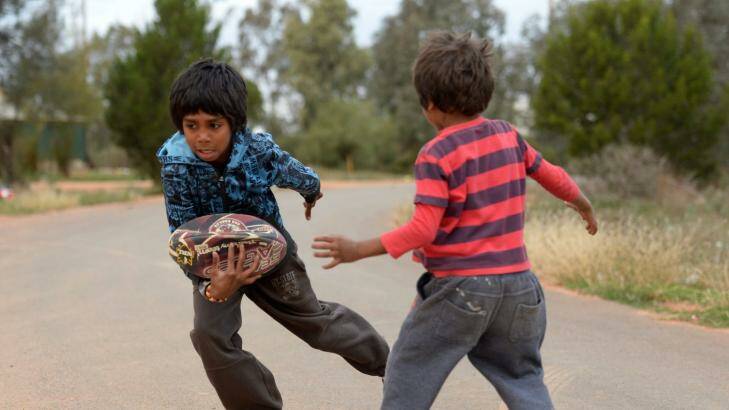 Aboriginal kids in Namatjira Avenue in Dareton near Mildura playing footy on the street. Photo: Justin McManus