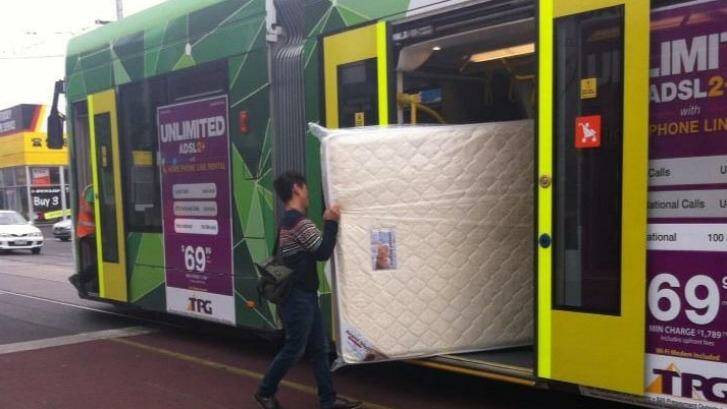 A new mattress heads to its new home via public transport in Melbourne. Photo: Mike Shuttleworth