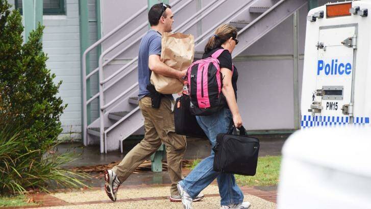 Police detectives leave Port Macquarie police station with bags of evidence. Photo: Nick Moir
