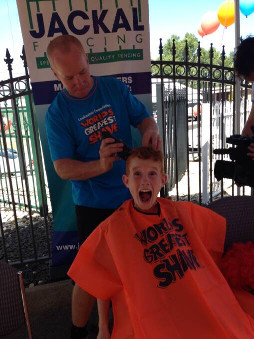 Cooper Hale, 10, has his locks shaved by his dad, Jamie. Picture: CONTRIBUTED