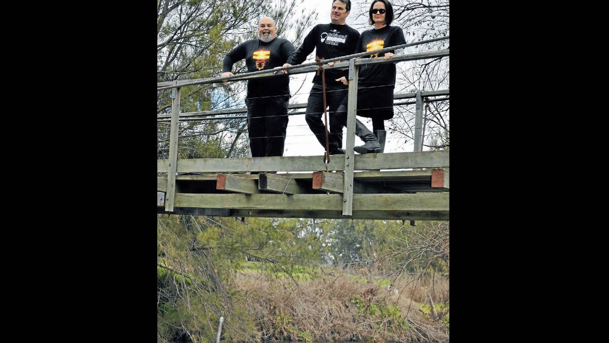 Age of Fishes Museum manager Warren Keedle and Corridor Project members Dylan Gower and Phoebe Cowdery on the Swinging Bridge over the Belubula River at Canowindra, discussing next week's exciting event. 