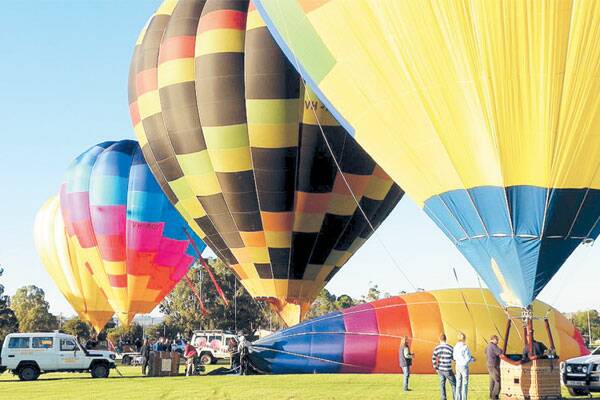 RISING TO THE OCCASION: Enthusiasts inflate their balloons before heading skyward in Canowindra at Easter. Photo Federation Fotos Canowindra