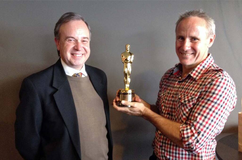 Richard Payten showing the Oscar to Lawrance Ryan, a prominent member of the arts community in Cowra.