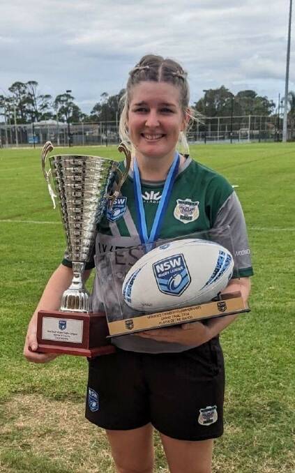 Alicia Earsman holding the trophies from the grand final for the Western Rams. See report on page 7.