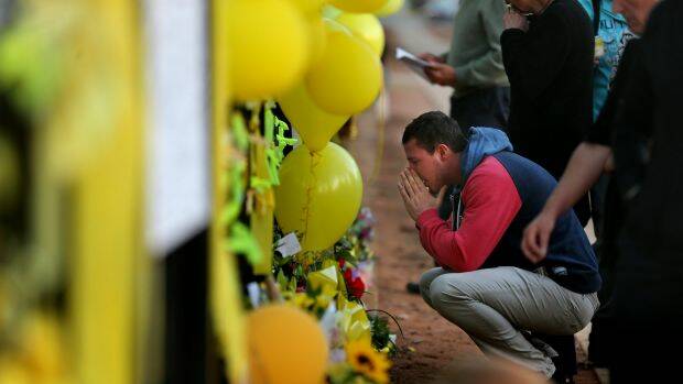 Crushed: Stephanie Scott's fiance Aaron Leeson-Woolley at the floral memorial on the gates of the Leeton High School. Photo: Kate Geraghty
