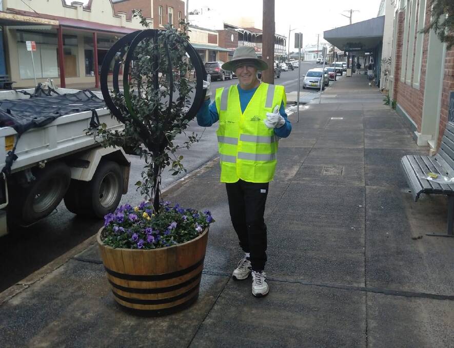 Canowindra Proud's Tommy Jeffs after planting flowers in the barrels along the main street. Photo supplied. 