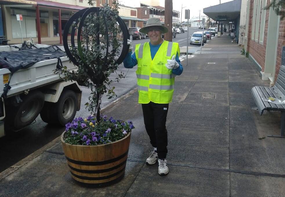 Tommy Jeffs after planting flowers in the barrels along the main street.