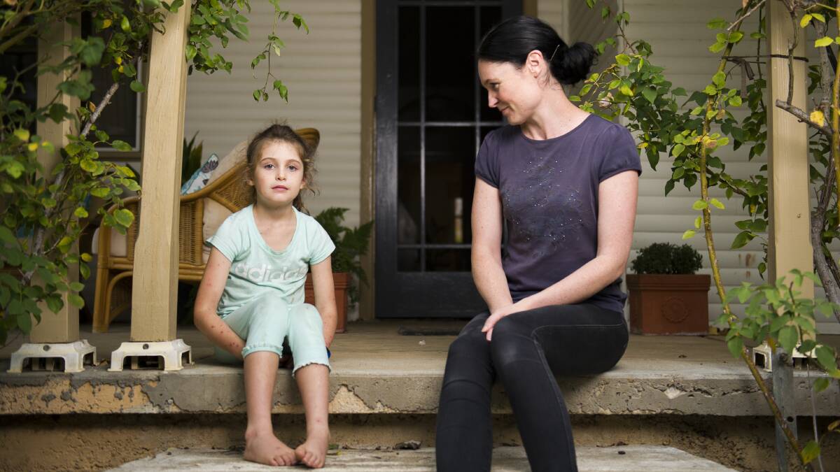 Evie Clark, 7, and her mother Samara Zeitsch at their Braidwood home a week after Evie was stung up to 300 times when she fell into a wasp nest. Photo: Dion Georgopoulos