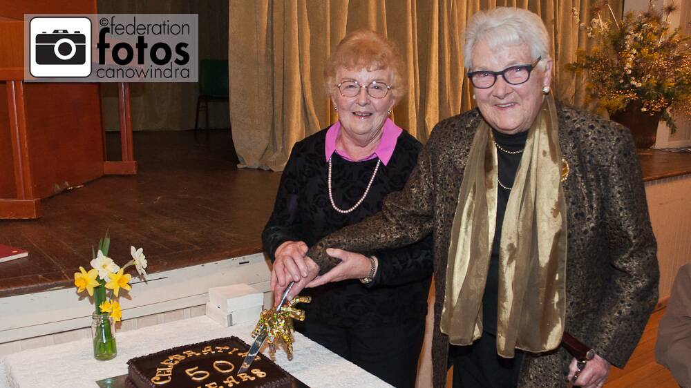 Mim Loomes and Dorothy Balcombe cut the cake at the Canowindra Historical Society's 50th celebrations. Photo by Federation Fotos