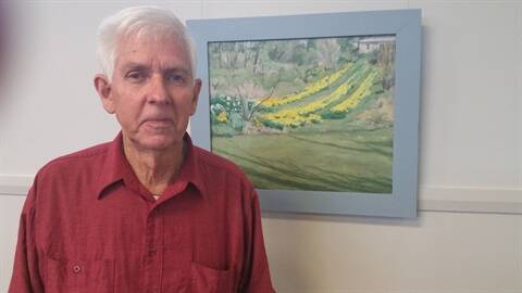 Michael Carroll with his painting "Gordon's Garden".