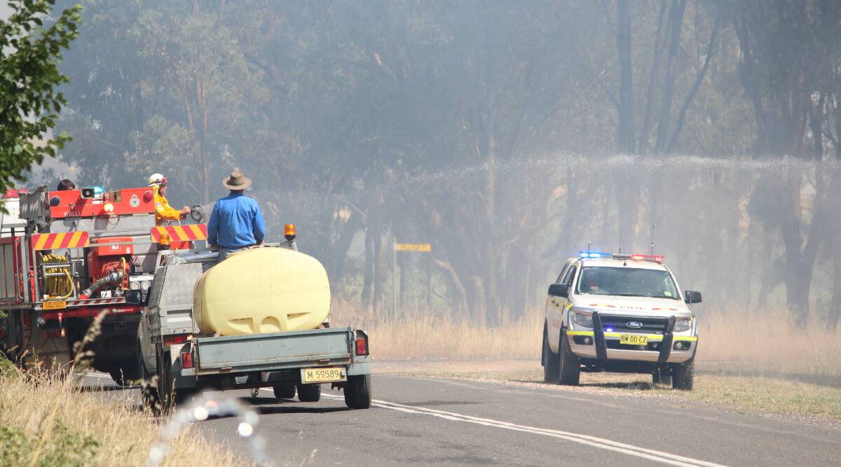 Emergency crews at the site of the Woodstock grass fire last December. A campaign has been launched for a 40km/h speed limit at emergency scenes.