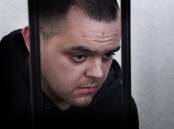 British citizen Aiden Aslin behind bars in a courtroom in Donetsk.