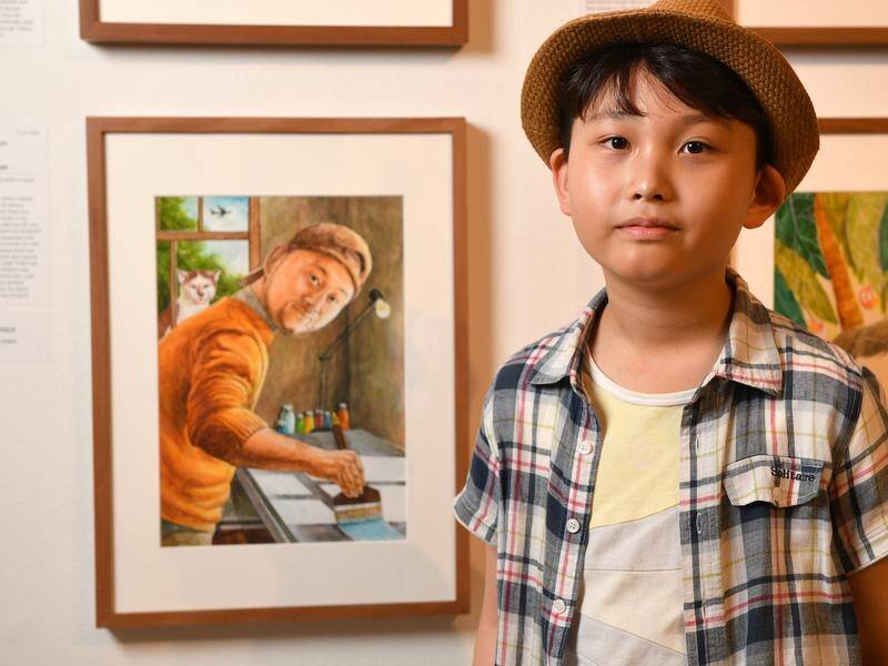 Ian Joseph Kim with the painting of his artist father that won him a Young Archie.
