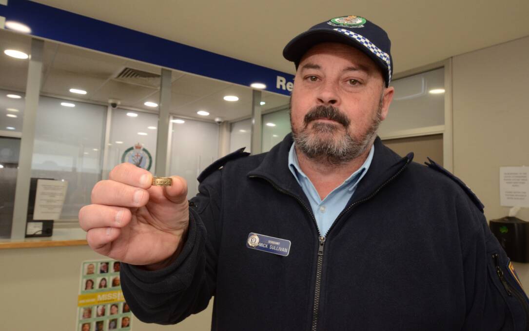 WHO IS SUE?: NSW Police Sergeant Mick Sullivan holding the ring that was handed in to Orange Police Station. Photo: JUDE KEOGH